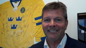 - Idag finns vårt monopol bara på pappret, säger vd Lennart Käll, vid Svenska Spel. Lennart Käll leende, framför en svensk hockeylandslagströja med autografer