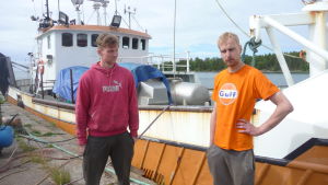 Axel Hellström och Jukka-Pekka Vironen står på kajen vid ett fiskefartyg.