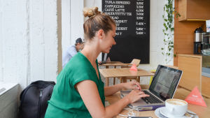 Maria Nurmela märkte inte att bordet var reserverat för lunchgäster. Dansare och koreograf Maria Nurmela sitter vid en laptop på IPI Kulmakuppila