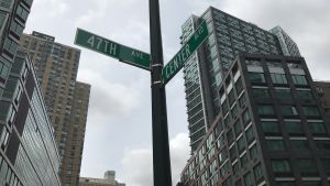 Center Boulevard är adressen Gatuskylt bland skyskraporna, hörnet av Center Boulevard och 47 avenue i Long island City
