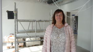 Doris Bäck. Doris Bäck i ett av de blivande klientrummen i Villa Holger. Bakom henne hänger ledningar från taket och en byggställning är uppställd.