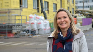 Mirjam Kalland är docent i familjeforskning och tidigare generalsekreterare för Mannerheims barnskyddsförbund Mirjam Kalland poserar framför ett halvfärdigt hus.