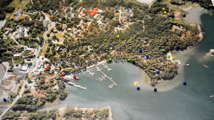 Knappnålar i olika färger symboliserar områden som är problematiska och fina platser som borde utvecklas. Karta över Nagu med knappnålar.