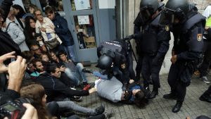 Kravallpolis håller nere två personer utanför en vallokal i Barcelona. Kravallpolis håller nere två personer utanför en vallokal i Barcelona.