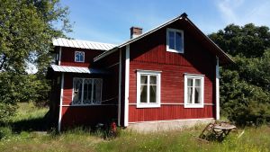 Den som anländer till Finland från utlandet ska under 14 dygn självmant hålla sig i karantän och “begränsa onödiga närkontakter”. Det är ändå tillåtet att bland annat röra sig mellan arbetsplatsen och hemmet. Utländska medborgare får ännu inte utan vägande skäl resa för att titta till sin sommarstuga. Röd stuga med vita knutar i sommargrönska på Berghamn i Houtskär.