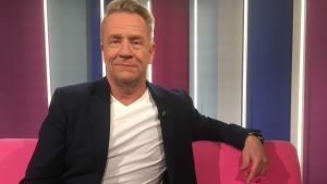 Olli Lindholm istuu Puoli seitsemän ohjelman sohvalla studiossa.
