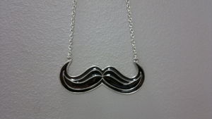 En Movember-mustasch som hängsmycke.