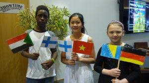 Salah Ibrahim från Sudan, Ly Bang från Vietnam och Hana Kardumovic från Bosnien har integrerats väl in i samhället. Tre barn står med flaggor i hand. En sudansk pojke viftar med Sudans och Finlands flaggor, en vietnamesisk flicka med Vietnams och Finlands flaggor och en bosnisk flicka med Bosniens och Tysklands flaggor.