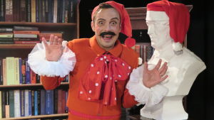 Jontti Granbacka spelar rollen som Festprisse i åretsjulkalender. En person utklädd till tomte poserar framför kameran.