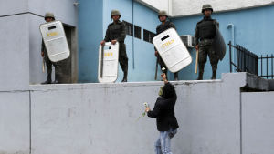 Säkerhetsstyrkorna har fått större befogenheter i och med veckans demonstrationer. Demonstrant räcker ut en blomma åt säkerhetsstyrkor som står på en mur.