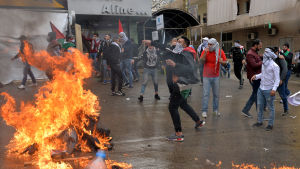 Demonstranter brände avbilder på Donald Trump, USA:s och Israels flaggor och kastade sten mot polisen efter att de hade tagit till tårgas och vattenkanoner. Demonstranter kastar sten under demonstration i Beirut.