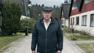 Rolf Lassgård har all anledning att börja le nu då hans Ove tävlar om en gyllene statyett. Rolf Lassgård poserar på gata i villaområde