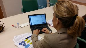 Många behöver stöd med det digitala i dag. Kvinna skriver på laptop bakifrån.
