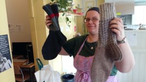 Janna Vehviläinen visar upp några av yllesockorna som donerats till bostadslösa. Janna Vehviläinen visar upp två par sockor som donerats till bostadslösa.