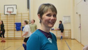 Anna Salmensaari koordinerar Sibbos invandrarlag. Anna Salmensaari med volleybollspel i bakgrunden.