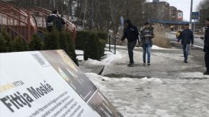 Fredagsbönen i Fittja lockar flera hundra muslimer till moskén. Mest är det män som kommer, barn och kvinnor är anvisade en särskild plats inne i moskén. Infomrationsplakat om Fittja moské, i bakgrunden unga män påväg till moskéen.