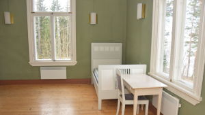 Villa Grantorp har bland annat fungerat som Raseborgs stads lägergård några dagar på somrarna. Ett rum med gröna tapeter och vita möbler i Villa Grantorp.