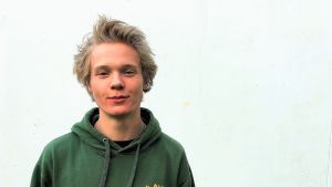 Troy Björkman beskriver sig som en global medborgare snarare som en finlandssvensk. Skateboardaren Troy Björkman mot vit vägg.