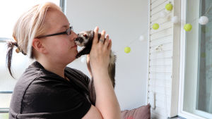 Djuren är bland det viktigaste i Heli Levänens liv. En kvinna håller upp en tamiller nära intill ansiktet och ser kärleksfullt på den.