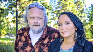 Peter Hallström och Anja Kontor. Peter Hallström och Anja Kontor med gröna träd i bakgrunden.