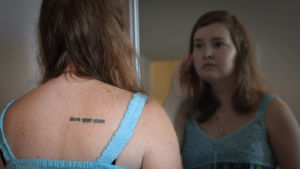 Mikaela har en tatuering på ryggen där det står "Medan jag andas hoppas jag" på latin. Mikaela Sallmén speglar sig.