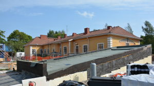 Ålderdomshjälpen är en fond som Björneborgsbon Verner Petrell via sitt testamente startat en gång i tiden. Det är Svenska Kulturfonden i Björneborg som har hand om fonden. På bilden syns det gamla trähuset Torkel. byggarbetsplats med en massa bråte framför det gamla huset torkel