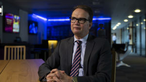 Velipekka Nummikoski föjer med Sveriges situation för att grannländer alltid intresserar mer än andra länder. Velipekka Nummikoski sitter vid ett bord.