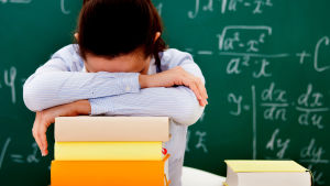 Att rensa huvudet kan vara bra innan du börjar plugga nya saker Trött skolelev böjd över sina skolböcker med svarta tavlan i bakgrunden.