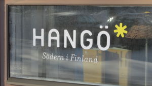 Hangöbor sticker sig gärna in på turistbyrån. Text i vitt där det står Hangö Södern i Finland på fönsterruta.