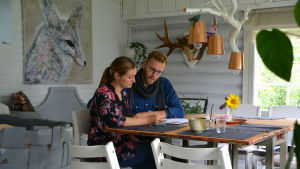 Familjen ska noggrannt fylla i hur de lever och konsumerar just nu. Merja och Jan-Christian sitter vid köksbordet och fyller i blanketter