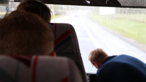 Det blir otaliga kilometrar på resande fot. Inifrån en buss. I bakgrunden skymtar vägen.
