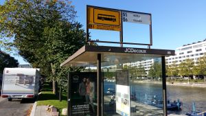 Ska en spårvagn eller buss stanna här år 2040? En busshållplats vid Åbo stadsteater, med reklam för Sokos.