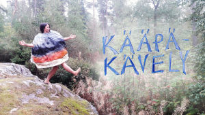Minna Pyykkö kääpäasussa kalliolla.