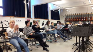 Elever och mobiler. Telefonerna plockas fram endast då de behövs i undervisningen. Skolelever sitter med mobiltelefoner i händerna på musiklektionen.