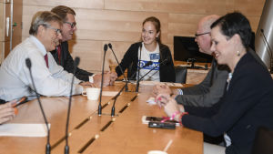 Minttu Kurki leder ordet i riksdagens utrikesutskott. Vid bordet sitter även riksdagsledamöterna Pertti Salolainen (Saml) , Matti Vanhanen (C), Eero Heinäluoma (SDP) och Maarit Feldt-Ranta (SDP). Minttu Kurki leder ordet i riksdagens utrikesutskott 10.10.2018. Hon är medlem i barnens styrelse vid Plan International i Finland