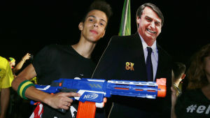 En anhängare firar tillsammans med en pappfigur som föreställer Bolsonaro. En anhängare firar med pappfigur som föreställer Bolsonaro.