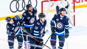 Lätt att le i december, men vem ska Laine spela med? Patrik Laine firar mål med lagkamrater.