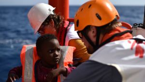 Här räddas ett barn ur havet 2016, till Aquarius. Människorättsorganisationer har kritiserat den italienska regeringen för att ha utövat påtryckningar på Panama, så att landet fråntog hjälpfartyget dess flagg. Flyktingar på Medelhavet