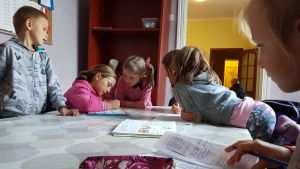 I Vännernas hus i Piski läser barnen läxor, äter och leker. Barn läser läxor hos en hjälporganisation i östra Ukraina