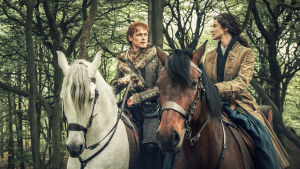 Outlander - Matkantekijä. Mies ja nainen ovat hevosen selässä ja katsovat toisiaan.