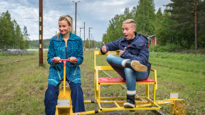 De som söker efter egendomliga och autentiska resmål där man möter intressanta personligheter kommer att få mest ut av våra restips, säger Hannamari. Egenlandin juontajat Hannamari Hoikkala ja Nicke Aldén ajavat resiinalla Suolahden rautatiemuseon huoltoraiteella. Hoikkala ajaa, Aldén istuu kyydissä.