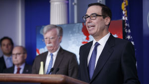 Den nationella säkerhetsrådgivaren John Bolton ( i bakgrunden) bar ett block i sin hand där han hade skrivit: 5 000 soldater till Colombia medan finansminister Steven Mnuchin lade fram sanktionerna. Den nationella säkerhetsrådgivaren John Bolton ( i bakgrunden) bar ett block i sin hand där han hade skrivit: 5 000 soldater till Colombia medan finansminister Steven Mnuchin lade fram sanktionerna