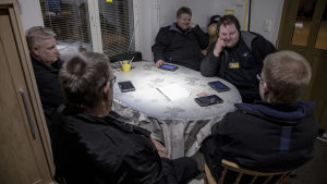 Tor-Erik Stolpe sitter med fyra andra taxichaufförer vid ett köksbord i chaufförernas lokal på Norra Strandgatan i Ekenäs.