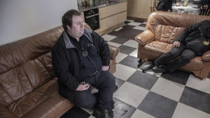 Taxichauffören Tor-Erik Stolpe sitter på soffan och ser på tv i taxichaufförernas lokal på Norra Strandgatan i Ekenäs.