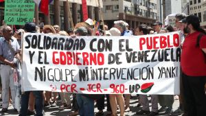Madurosupportrar demonstrerar mot den internationella kontaktgruppens första möte om krisen i Venezuela i Montevideo, Uruguay. Texten på skylten lyder ungefär "Solidaritet med folket och med den venezuelanska regeringen. Ingen kupp. Ingen "Yankee"-intervention. Madurosupportrar demonstrerar mot den Internationella kontaktgruppens första möte angående krisen i Venezuela.