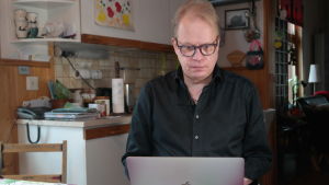 Peter Sandström är hemma från Nykarleby. Hans senaste bok Mamma november kom ut ifjol. Författaren Peter Sandström siier och jobba vid sin dator vid sitt köksbord