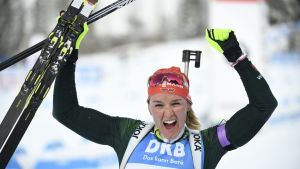 Glad Denise Herrmann firar sitt VM-guld. Skidskytten Denise Herrmann höjer armarna i en segergest.