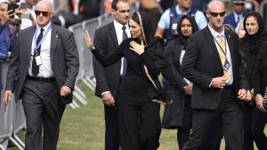 Premiärminister Jacinda Ardern vinkade till publiken när hon lämnade fredagsbönen i Hagley Park, omgiven av säkerhetsvakter. Premiärminister Jacinda Ardern vinkade till publiken när hon lämnade fredagsbönen i Hagley Park, omgiven av säkerhetsvakter.