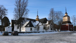 Bland annat i Närpes ordnas möjlighet att gå till nattvard på skärtorsdagen. En vit kyrka med svart tak. Två bilar står på gården.