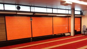 Muslimerna ber mot Mecka, den orangea väggen visar rätt riktning. Den oranga väggen i bönerummet visar riktningen mot Mecka, dit bönerna riktas.